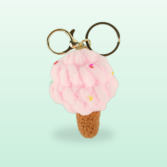 Plush ice cream cone keychain, strawberry pink with sprinkles and gold rings, on a mint background
