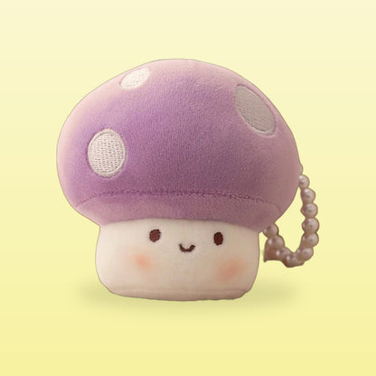 Purple mushroom plush keychain with white spots and a happy face