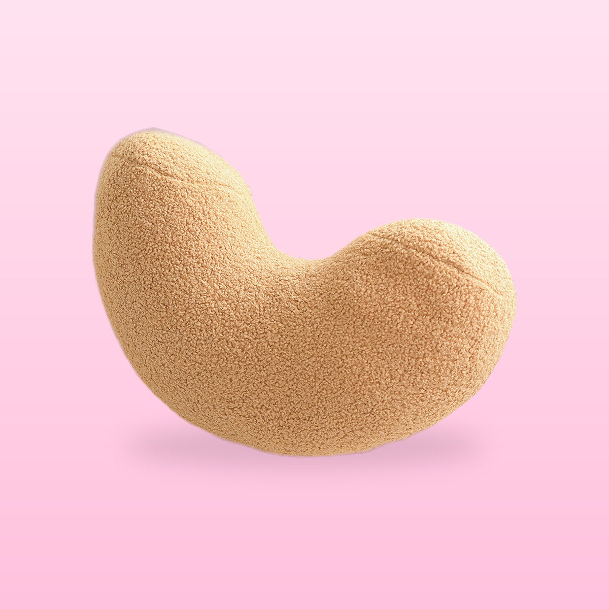 Camel tan cashew shaped boucle cushion, on a bubblegum pink background