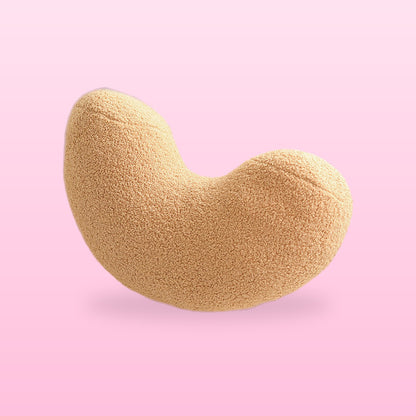 Camel tan cashew shaped boucle cushion, on a bubblegum pink background