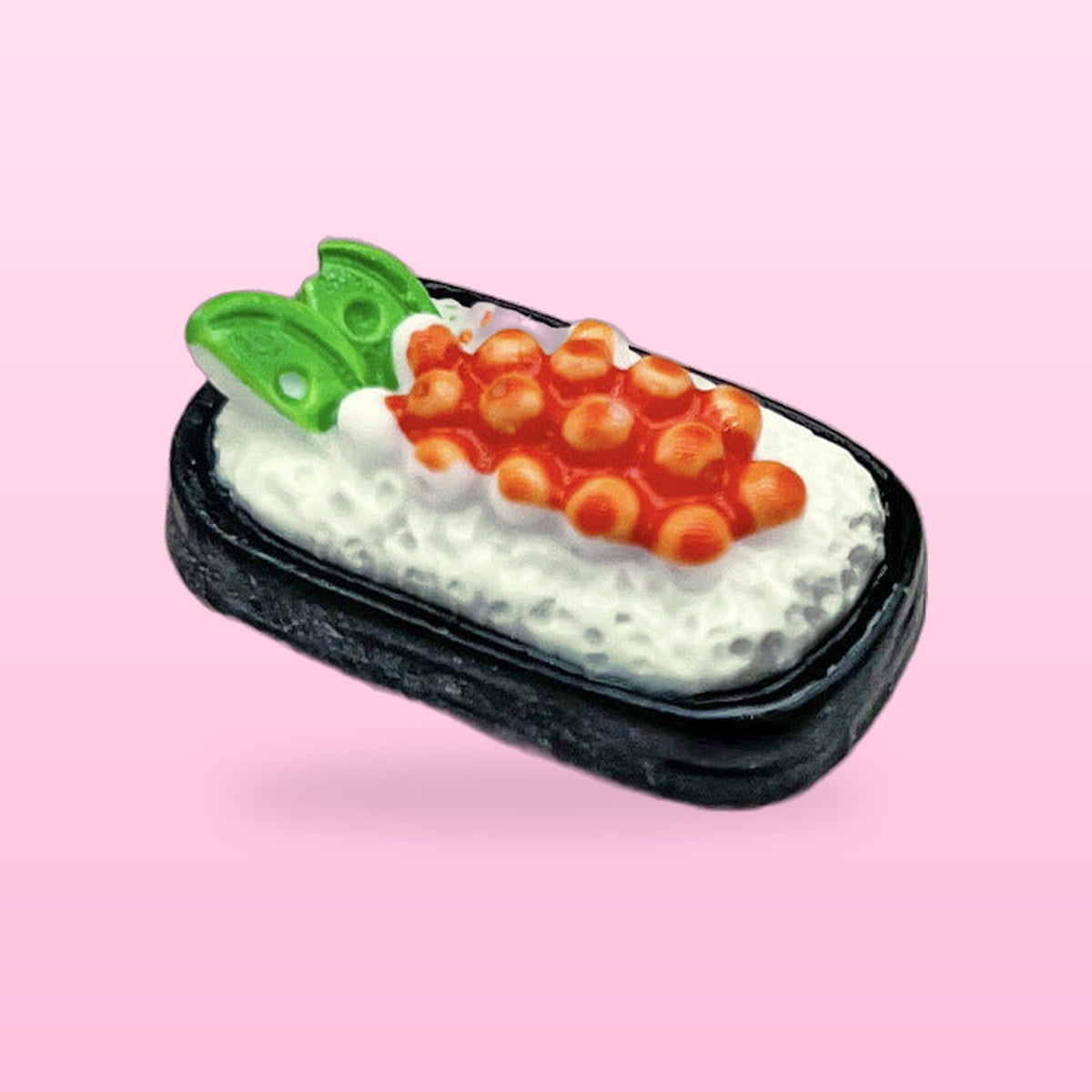 Salmon roe sushi miniature food fridge magnet in a black tray, on a pink background