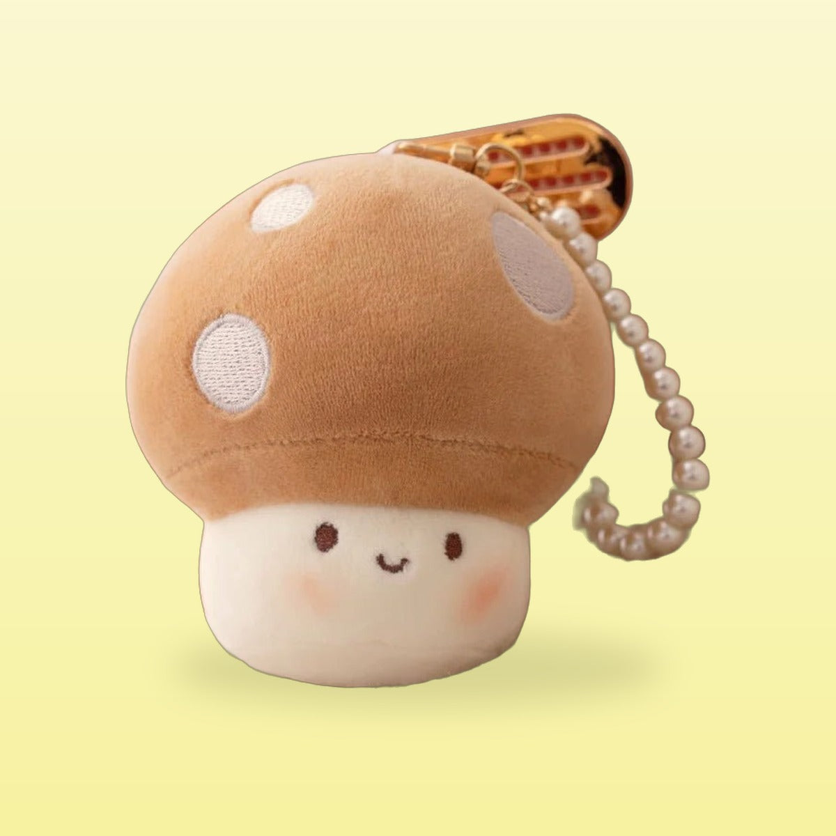 Brown mushroom plush keychain with white spots and a pearl strap