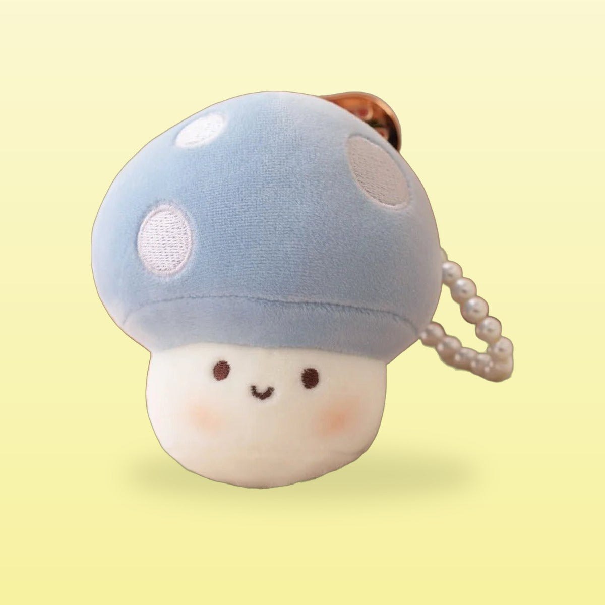 Blue mushroom plush keychain with white spots and rosy cheeks
