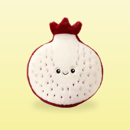 Pomegranate plush in white with a red crown top and a smiling face, on a butter yellow background