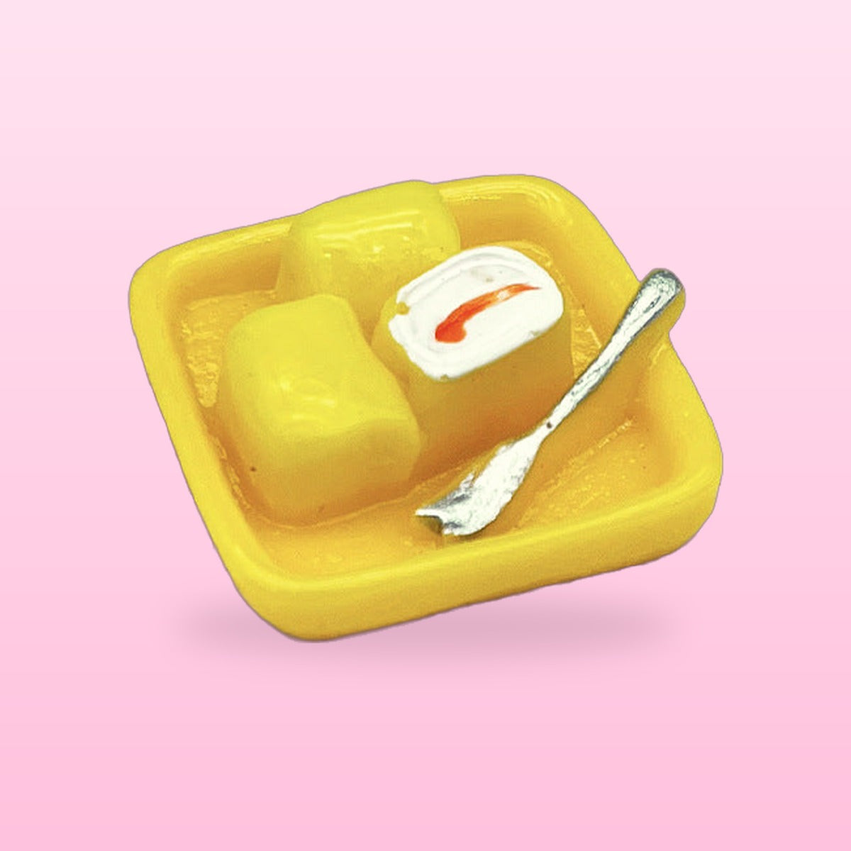 Mango pudding miniature food fridge magnet with a tiny silver spoon, on a pink background