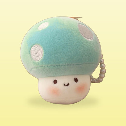 Mint mushroom plush keychain with white spots and a smiling face