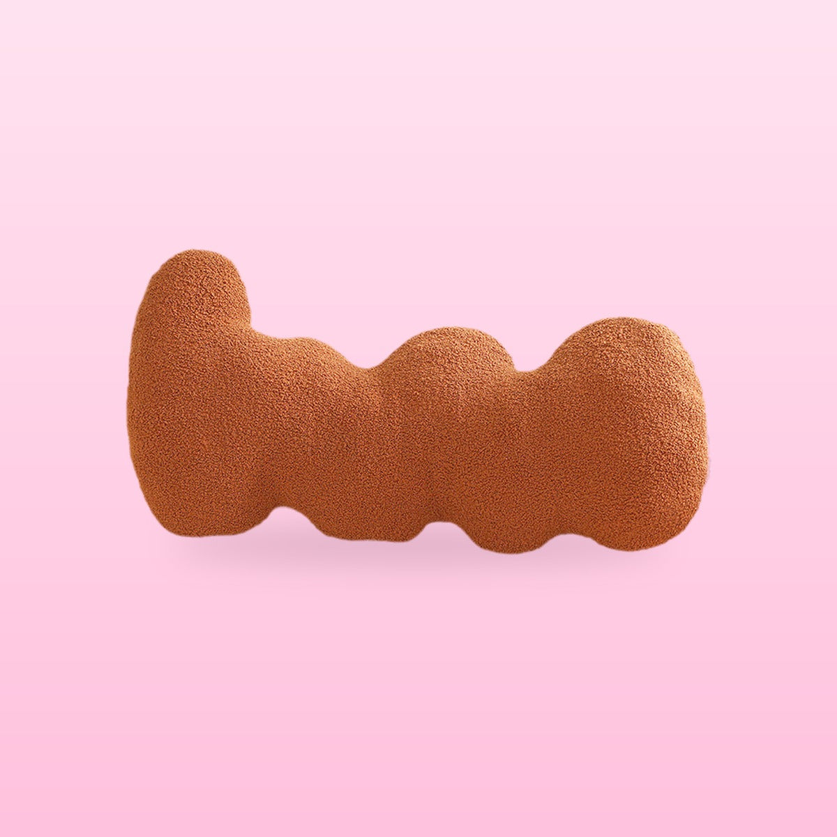 Chocolate brown wavy bolster cushion with rounded lobes, on a bubblegum pink background