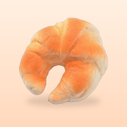 Crescent croissant slow rise bread squishy on a soft peach background