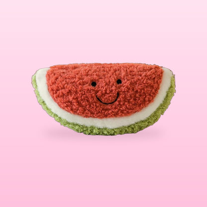 Fluffy watermelon slice plush with a green rind and a smiling face, on a bubblegum pink background
