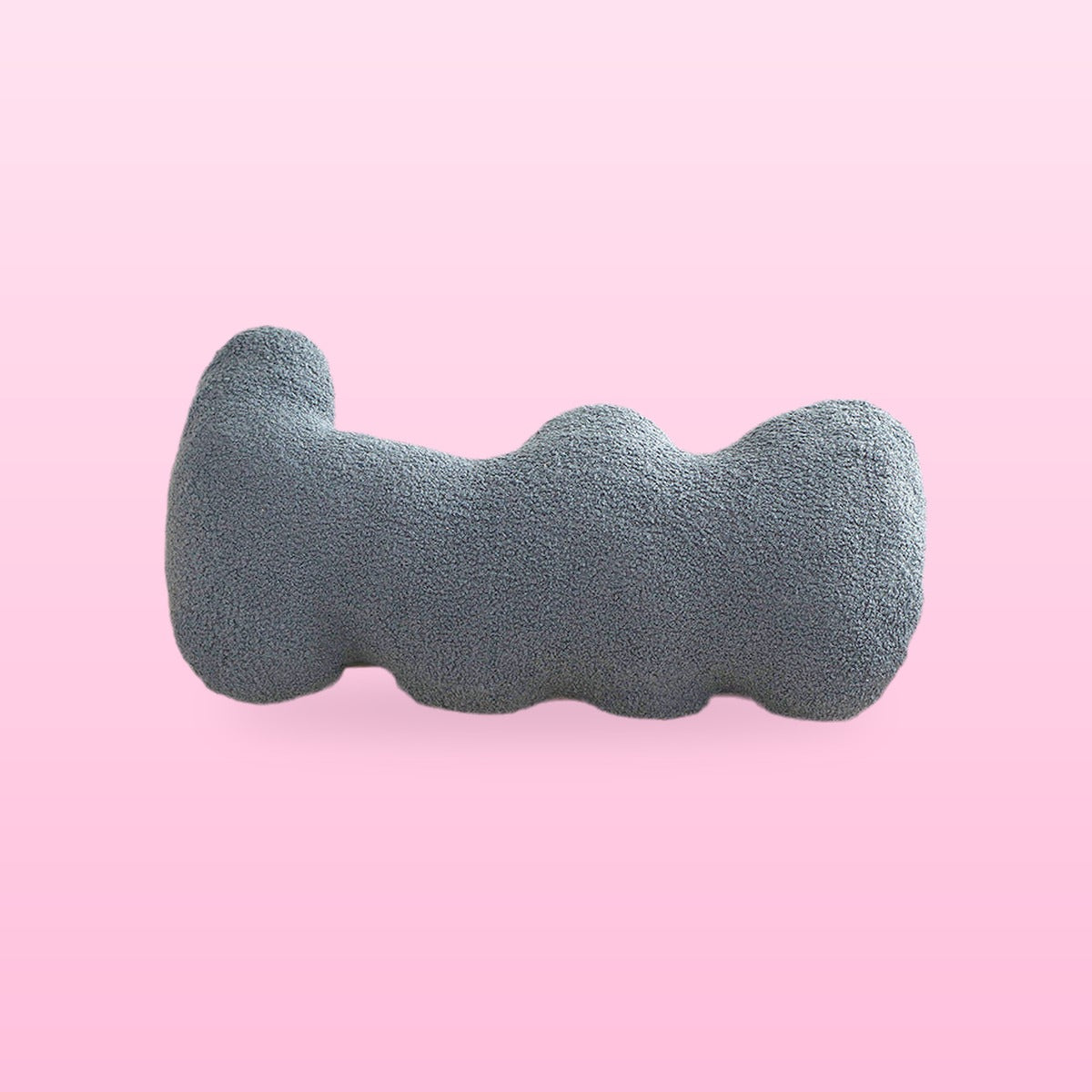 Fog blue wavy bolster cushion in blue grey boucle with rounded lobes, on a bubblegum pink background