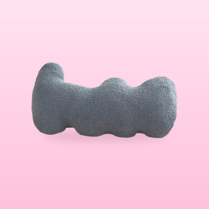 Fog blue wavy bolster cushion in blue grey boucle with rounded lobes, on a bubblegum pink background