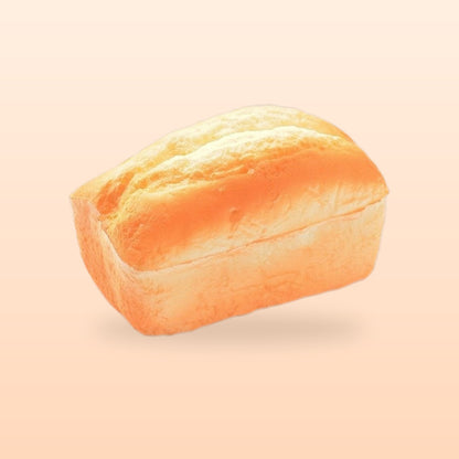 Split top loaf slow rise bread squishy, on a soft peach background