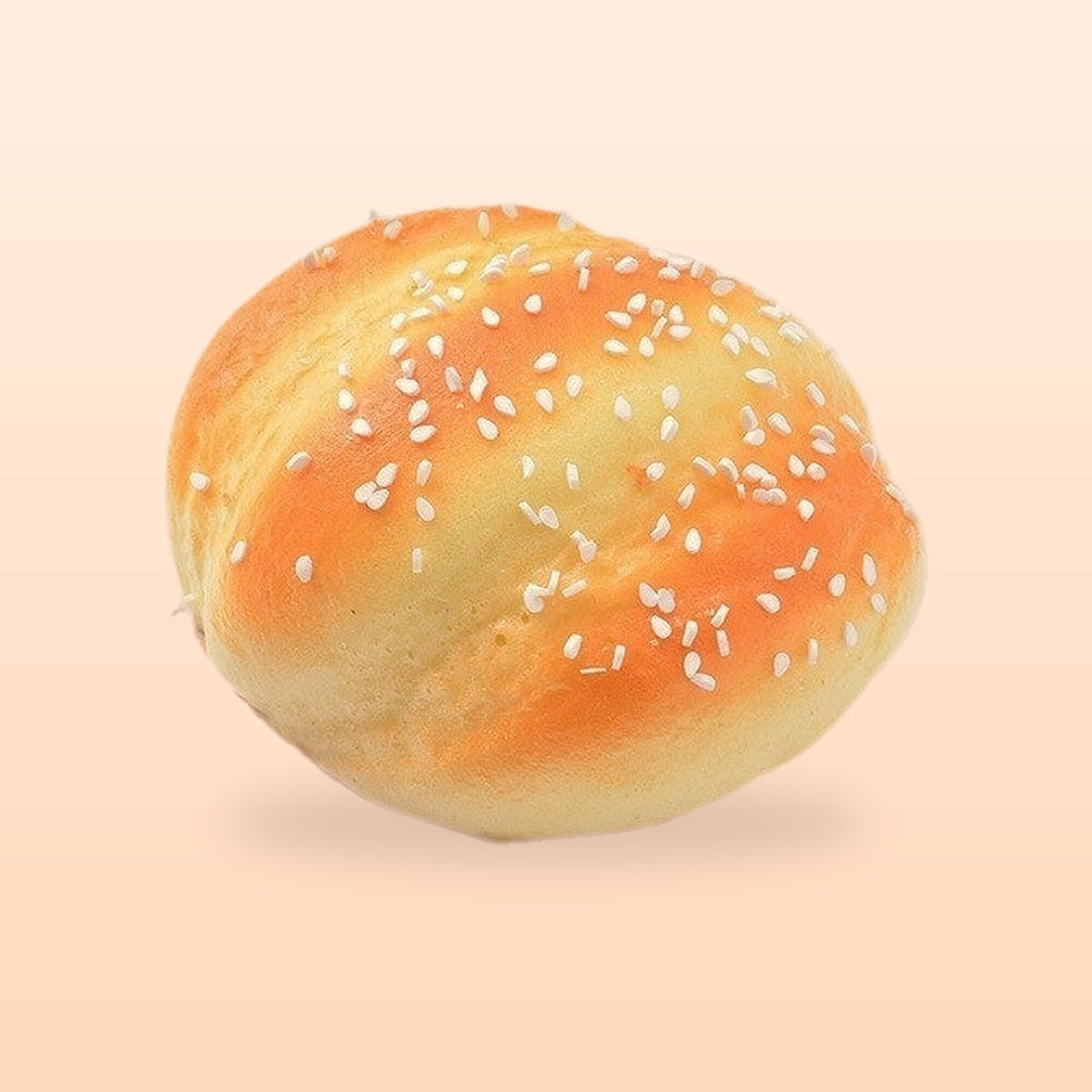 Sesame bun slow rise bread squishy, on a soft peach background