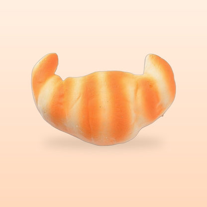 Croissant slow rise bread squishy on a soft peach background