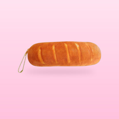 Golden baguette plush pencil case with a gold bead zip pull, on a bubblegum pink background
