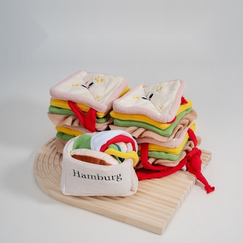 Stack of burger and sandwich snuffle pet toys on a round wooden board
