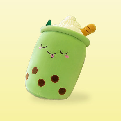 Green ice cream milk tea plush pillow with a sleepy face and cream top, on a butter yellow background