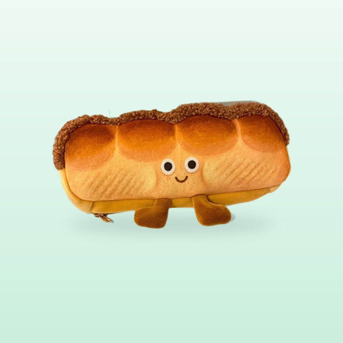 Bread loaf plush pencil case with a smiley face and little feet, on a mint background