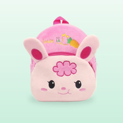 Pink bunny plush mini backpack with floppy ears and a flower, on a mint green background