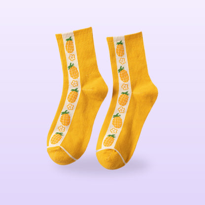 Yellow socks with a white stripe and pineapples, ribbed crew pair, on a lilac background