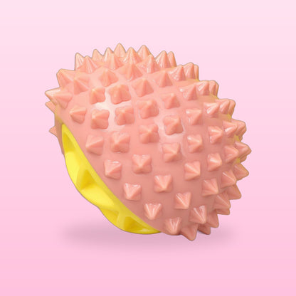 Pink durian squeaky dog chew toy with a yellow centre, on a pale pink background