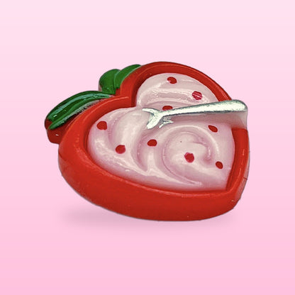 Strawberry heart dessert miniature food fridge magnet with a tiny silver spoon, on a pink background