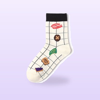 Cream grid cotton sock with a black cuff and little food motifs, on a soft lilac background