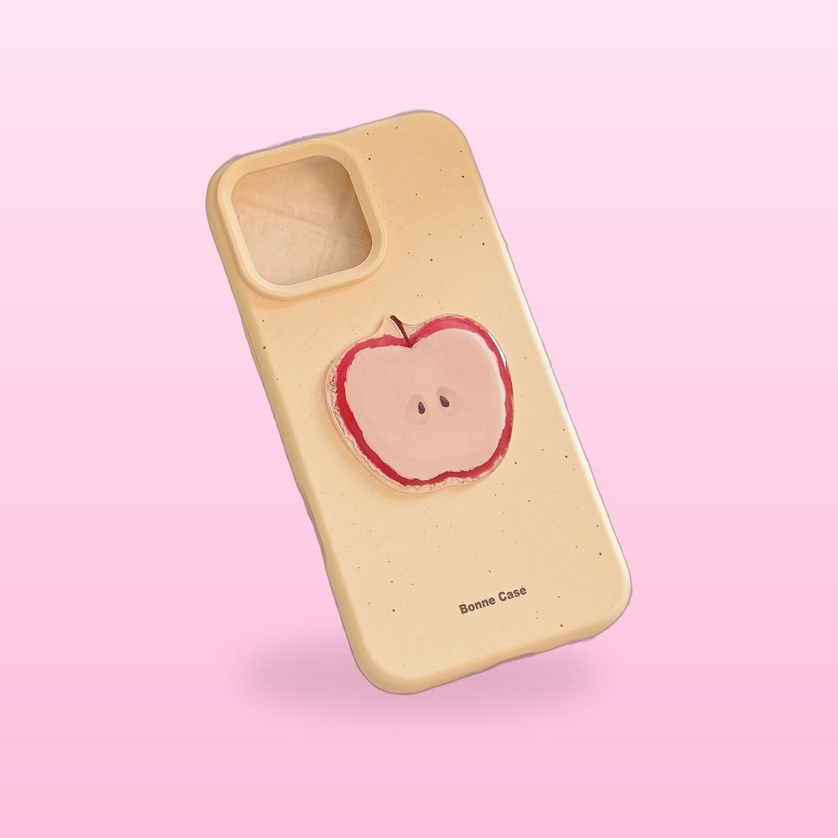 3D fruit iPhone case, cream yellow with a red apple half, on a pink background