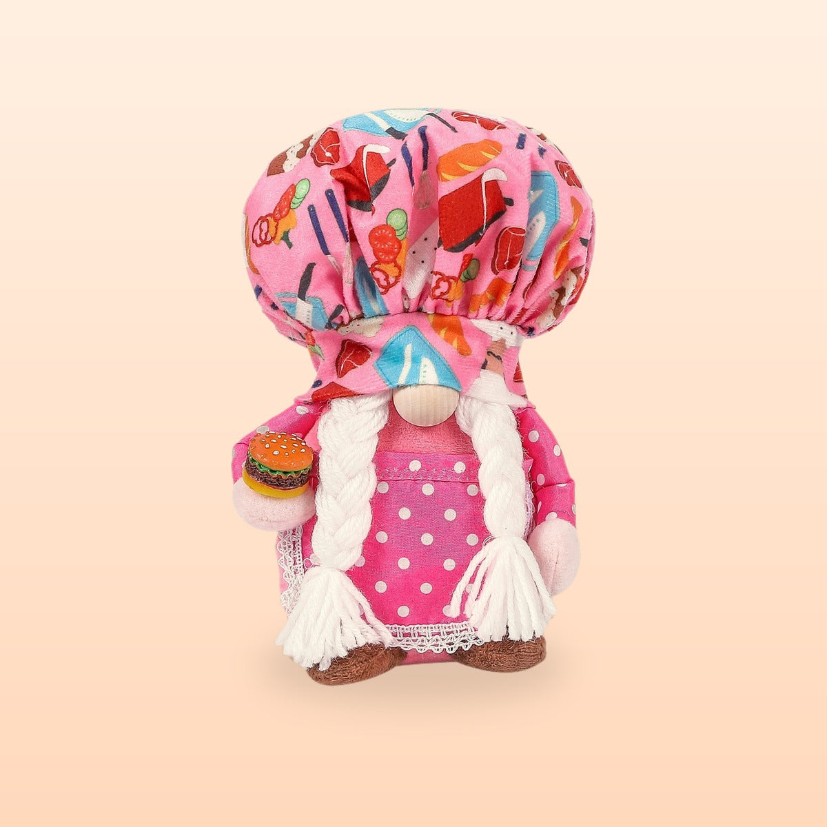 Pink hamburger chef plush gnome with a food print hat, white plaits and a tiny burger, on a peach background