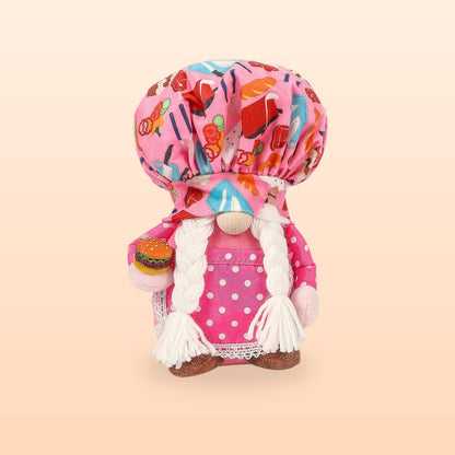 Pink hamburger chef plush gnome with a food print hat, white plaits and a tiny burger, on a peach background