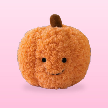 Fluffy orange pumpkin plush with a smiling face, on a bubblegum pink background