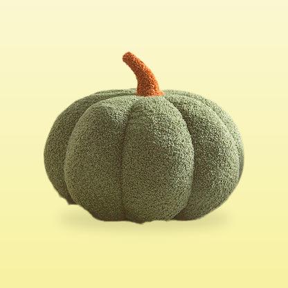 Teddy pumpkin plush cushion, forest green with a brown stem, on a butter yellow background