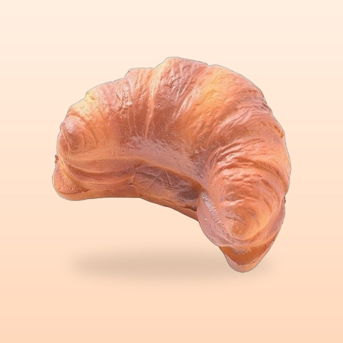 Mini croissant slow rise bread squishy on a soft peach background