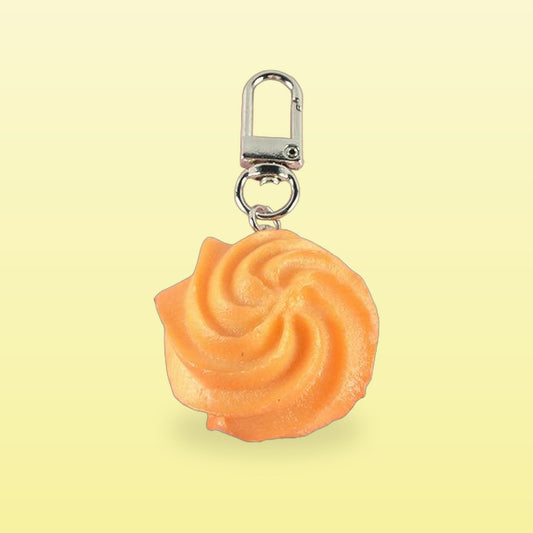 Swirl butter cookie keychain with a silver swivel clasp, on a butter yellow background