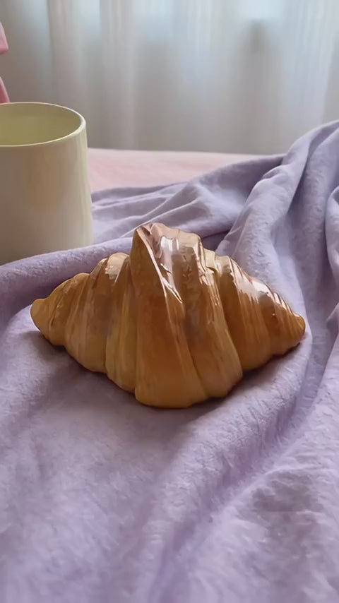 Croissant lamp switched on by the button underneath, then glowing warm amber on a bedside table