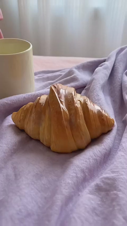 Croissant lamp switched on by the button underneath, then glowing warm amber on a bedside table