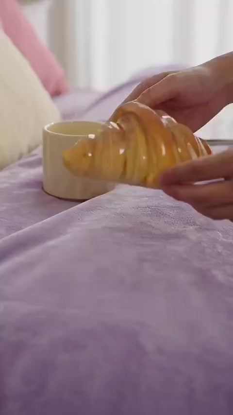 Croissant night light switching on and glowing warm amber on a bedside table