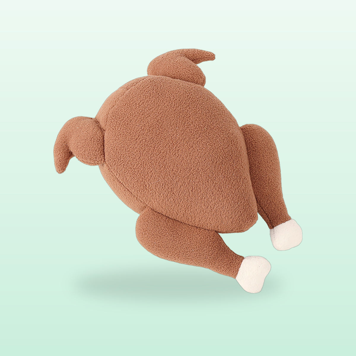 Brown fleece roast chicken snuffle dog toy with white bone tips, on a mint background