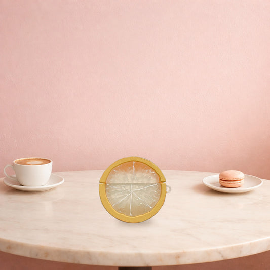 Yellow lemon slice AirPods case on a marble cafe table