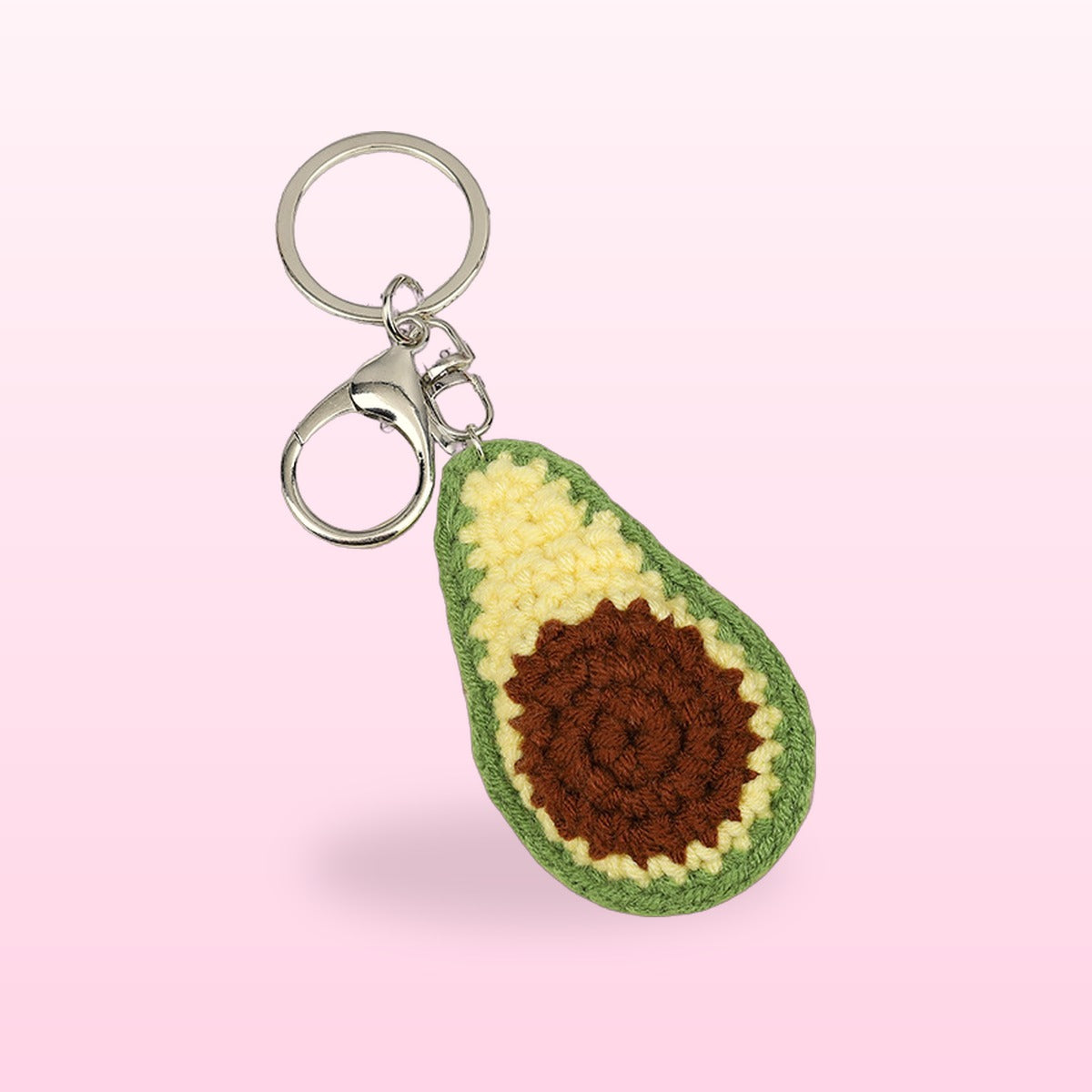 Close up of the crochet avocado keychain with a brown stone and silver clasp