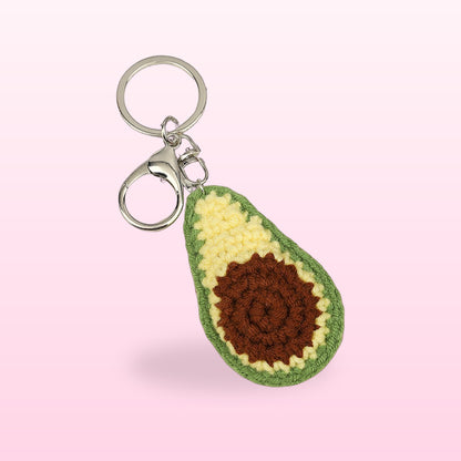 Close up of the crochet avocado keychain with a brown stone and silver clasp
