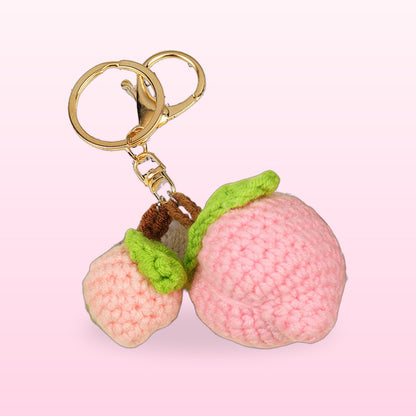 Close up of the crochet peach pair keychain with green leaves