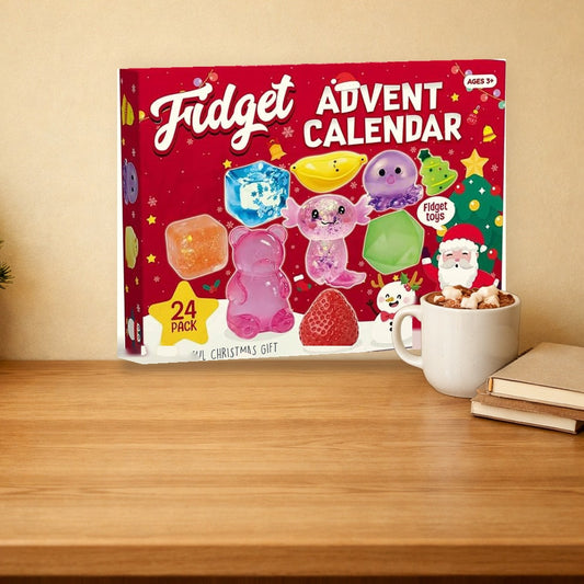 Squishy advent calendar box standing on a wooden desk behind a mug of hot chocolate, with a mini Christmas tree nearby