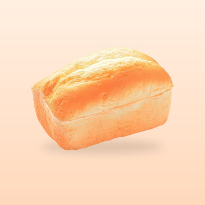 Split top loaf slow rise bread squishy, on a soft peach background
