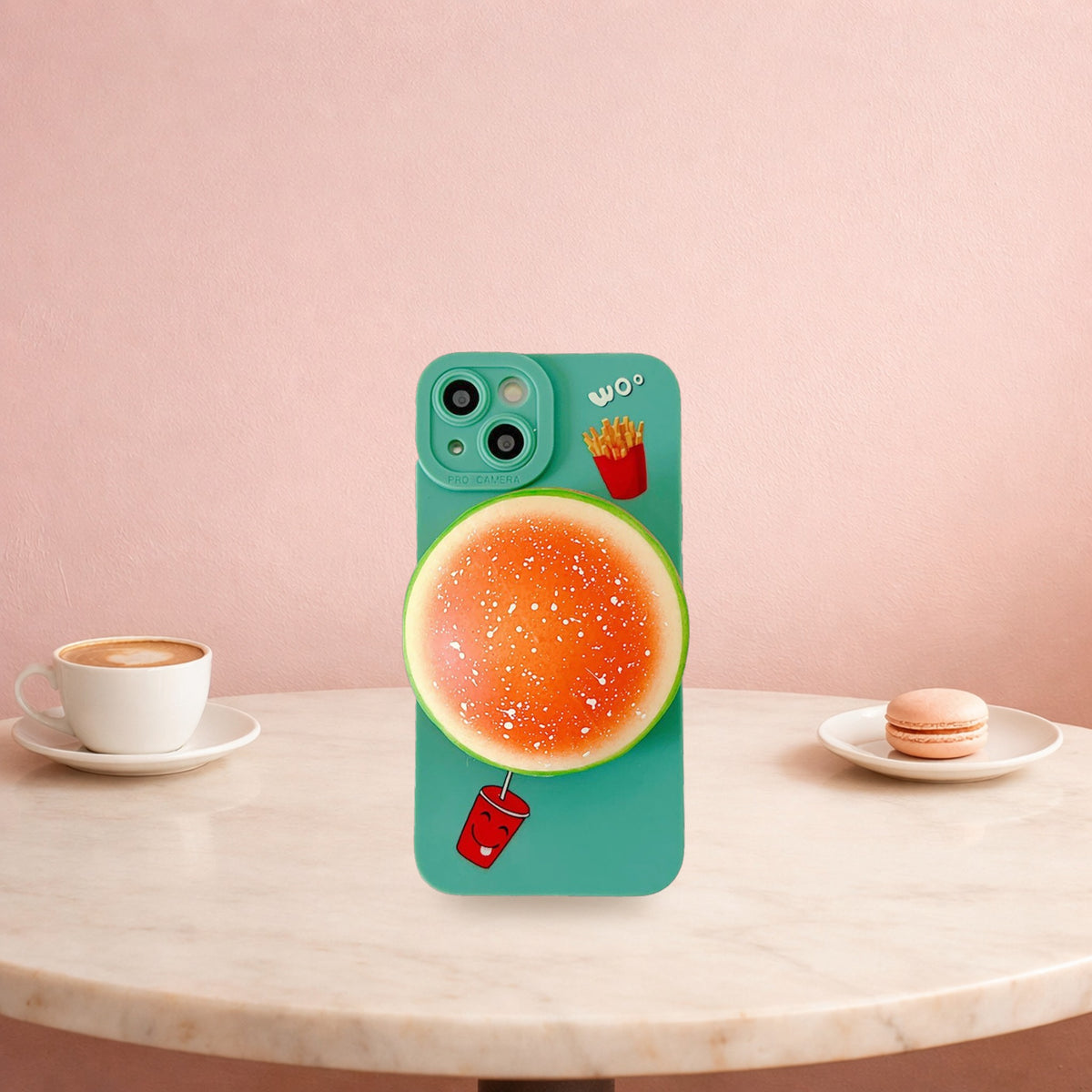 Green squishy burger phone case for iPhone standing on a marble cafe table