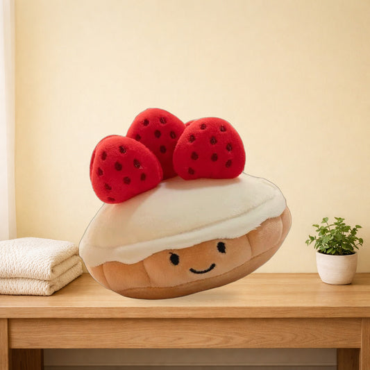 Strawberry muffin plush sitting on an oak bench in a pastel bedroom