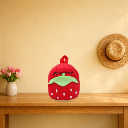 Red strawberry plush mini backpack on a light oak console table