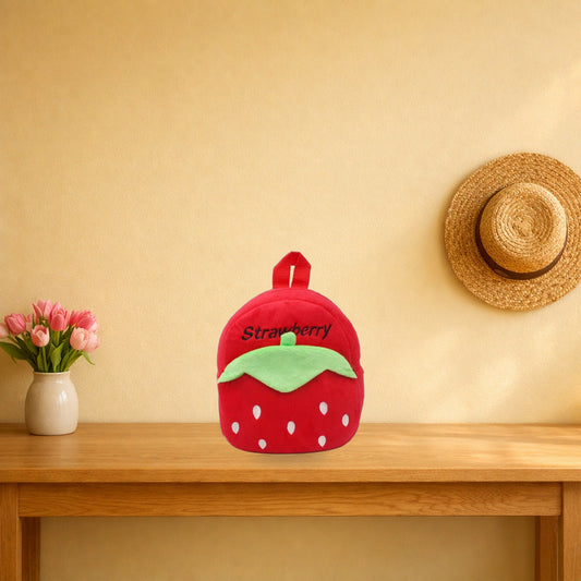 Red strawberry plush mini backpack on a light oak console table