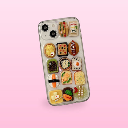 Clear iPhone case covered in resin sushi, toast, egg and sandwich charms, on a soft pink background