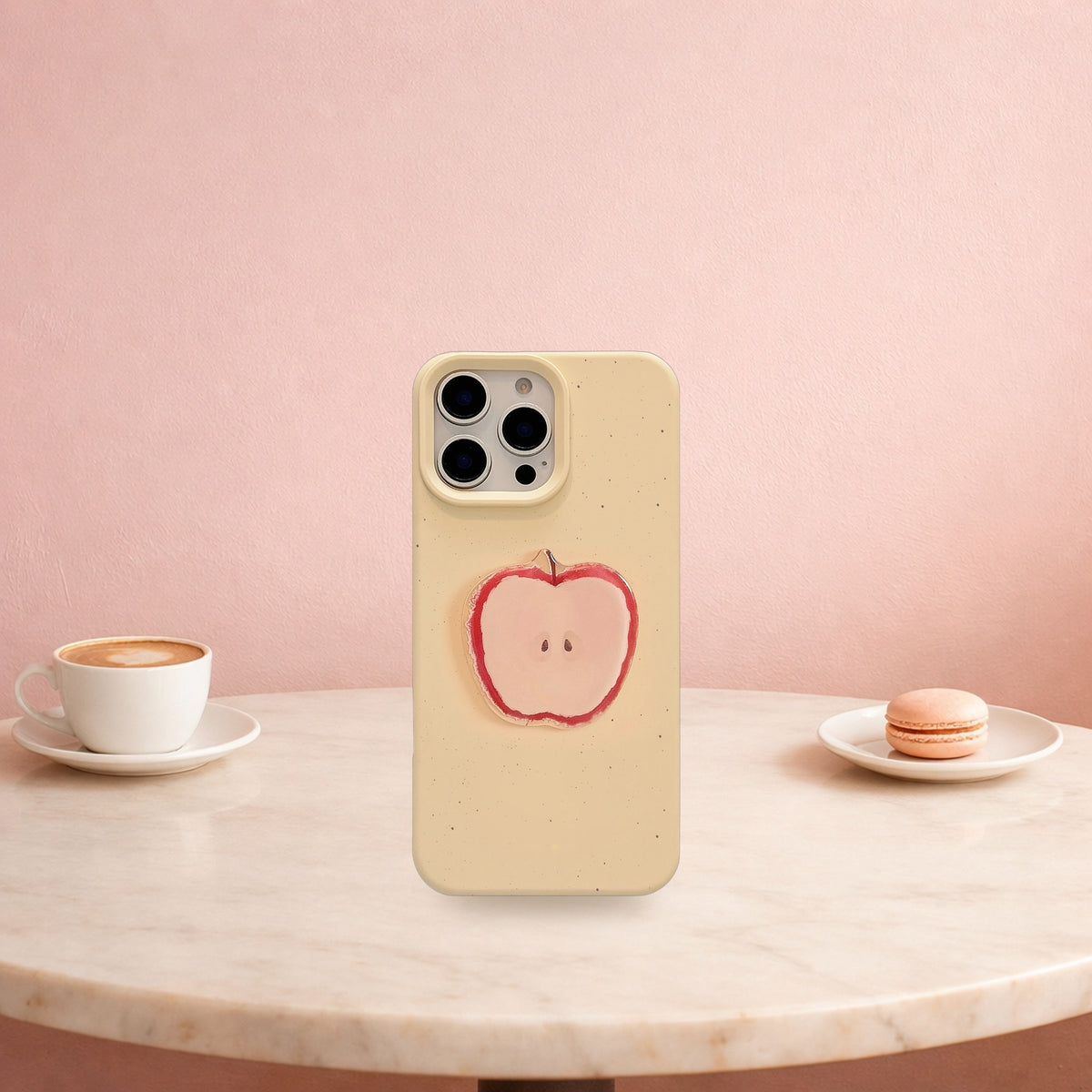 Cream yellow 3D apple iPhone case standing on a marble cafe table